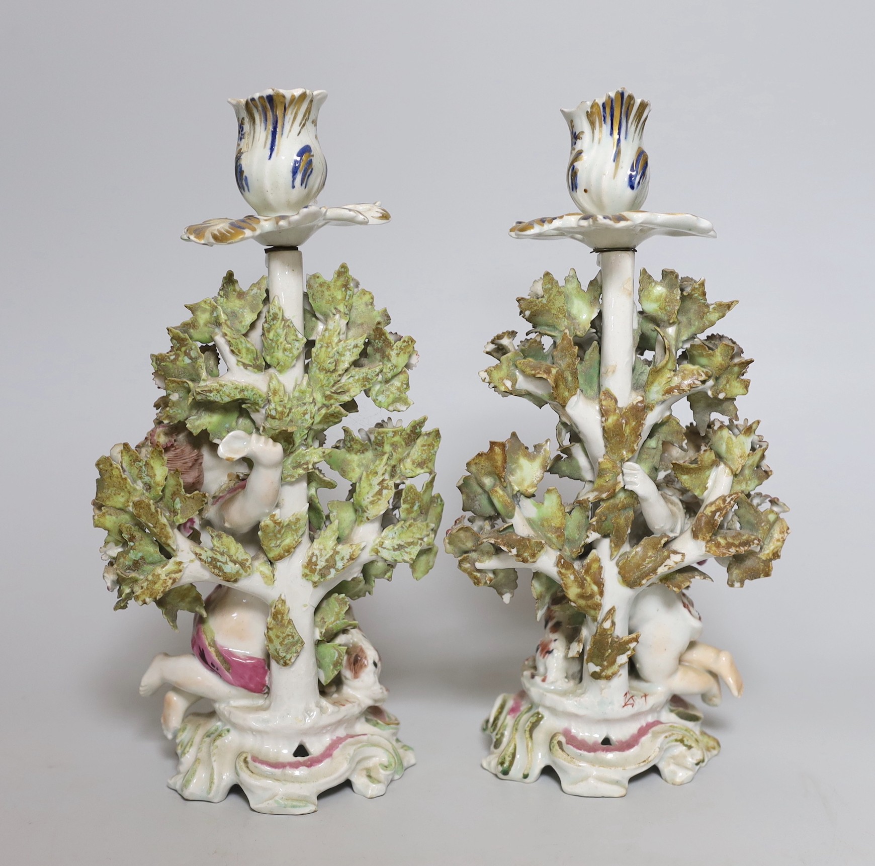 A pair of 18th century Bow putti figural candlesticks, 24cm